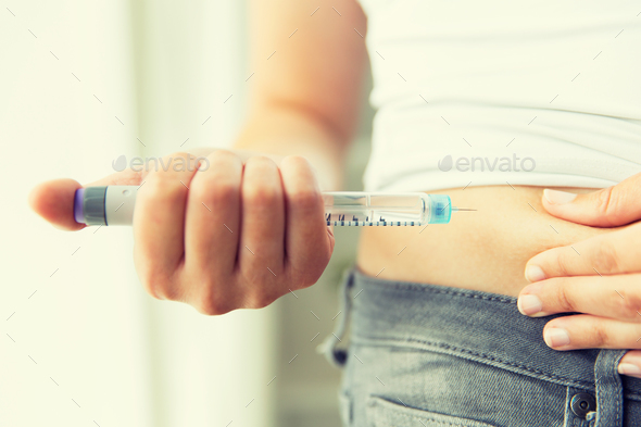 close up of hands making injection by insulin pen - Stock Photo - Images