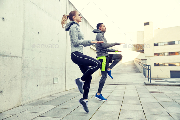 happy man and woman jumping outdoors - Stock Photo - Images