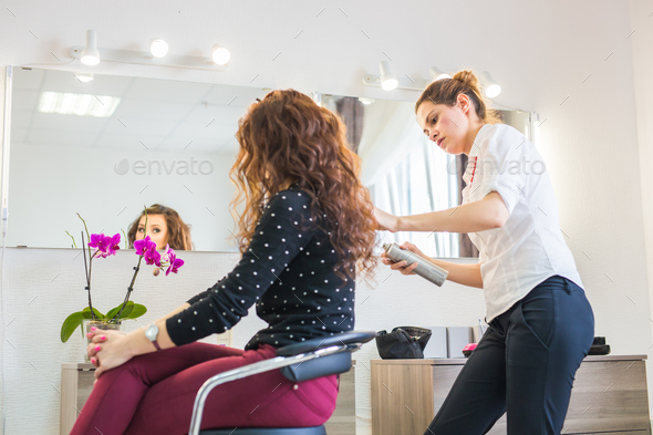 Hairdresser doing haircut for women in hairdressing salon