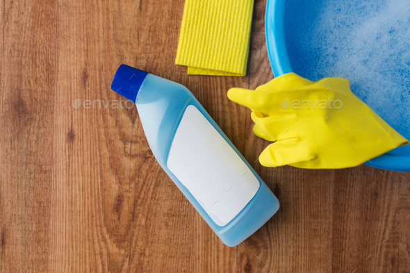 basin with cleaning stuff on wooden background