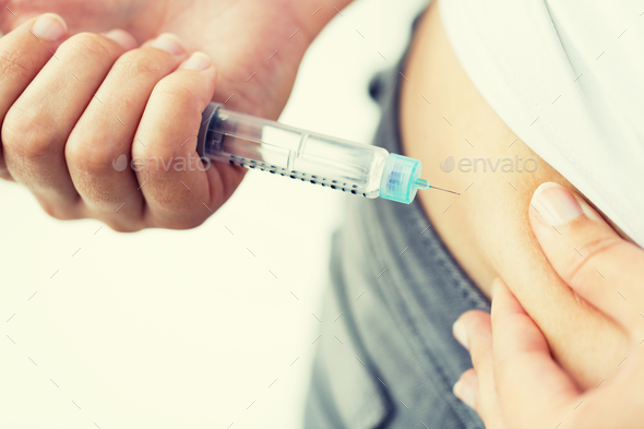close up of hands making injection by insulin pen - Stock Photo - Images