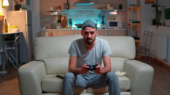 Upset Pro Gamer Sitting in Front of Television Losing Soccer Video Games alt