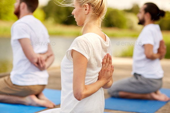 group of people making yoga exercises outdoors