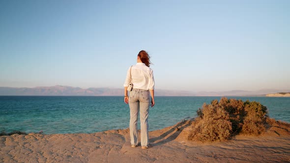Unrecognizable Woman Standing Near Cliff Over Mediterranean Ionian Sea alt
