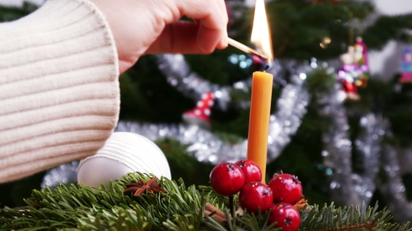 Lighting Candle with Matches in Front of the Christmas Tree