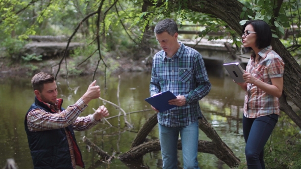 Three Scientists Exploring Water in Lake alt