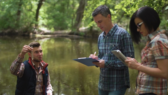Three Scientists Exploring Water in Lake alt