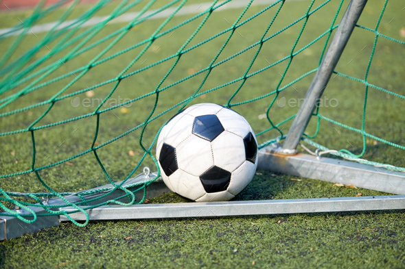 soccer ball at goal net on football field
