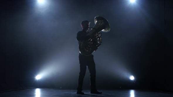 Instrumentalist Plays on Wind Instrument Classical Melody. Studio in Smoke alt