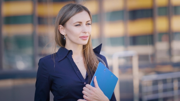 Street. Territory of the Business Center. A Young Girl Looks Into the Distance and Straightens Her alt