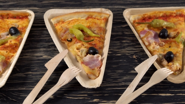 Slices of Pizza on Wooden Plates. Party Concept.