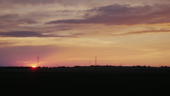The Disc of the Setting Sun Over the Field in the Countryside View From the Window of a Moving Car alt