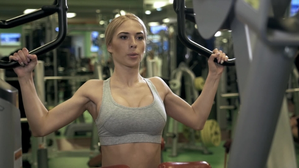 Young Fitness Woman Execute Exercise with Exercise-machine in Gym alt