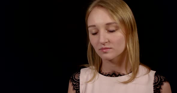 Calm and Beautiful Blonde Girl Is Standing in Black Background, Closeup Portrait in Studio alt
