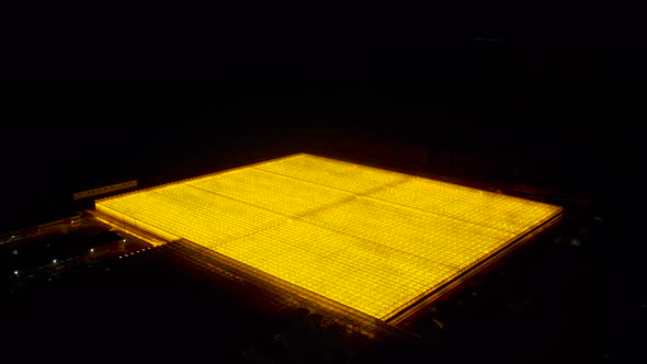 Greenhouse Rooftop Glowing at Night Aerial View