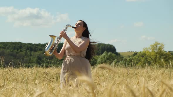 Beautiful Longhaired Brunette Woman Jazz Performer Plays Saxophone Outdoors in Field with Blue Sky alt