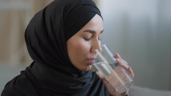 Close Up Arabian Young Woman with Perfect Skin in Hijab Drinking Glass of Clear Filtered Water alt
