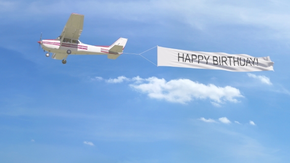Small Propeller Airplane Towing Banner with HAPPY BIRTHDAY Caption in the  Sky by moovstock