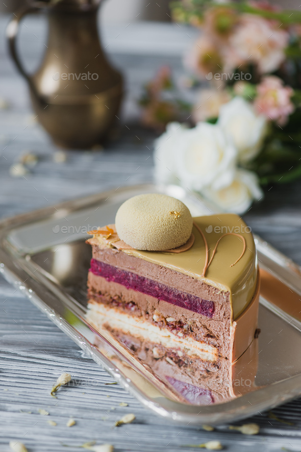 Bakery with piece of unusual yellow mousse cake with almond dacquoise, raspberry confit, crispy