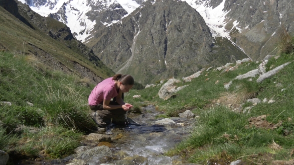 Traveler Drinking and Washing Face in Creek