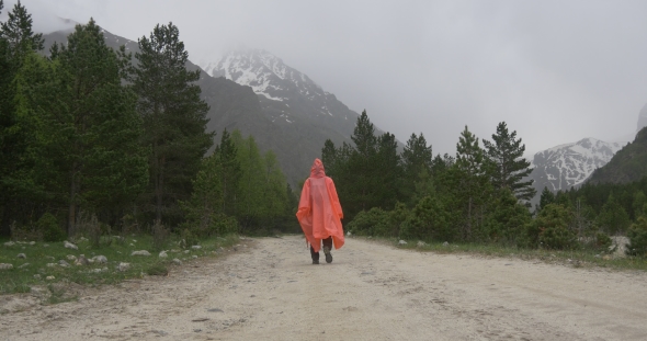 Woman in Raincoat Hiking in Mountains in Rain