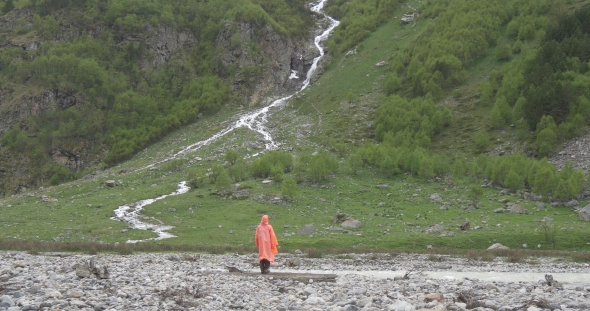 Person Standing Near Waterfall Under Rain