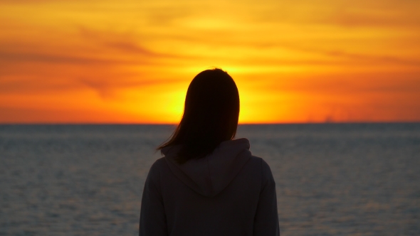 Silhouette of Woman Watching Sunset at the Sea