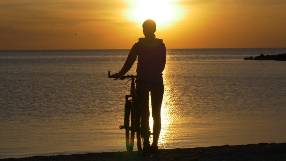 Silhouette of Woman with Bicycle Near Sea