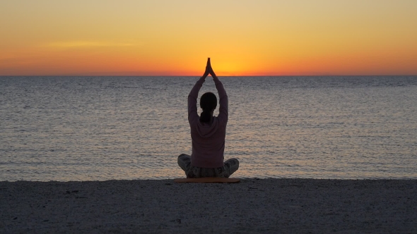 Woman Doing Yoga on Sunset Near the Sea