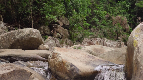 Tourist Crosses River Flowing Between Big Stones in Jungles alt