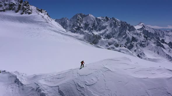 Climber in a red siut walking Up Mountain Expedition Aerial Flight Epic Mountain Range Climb To Succ