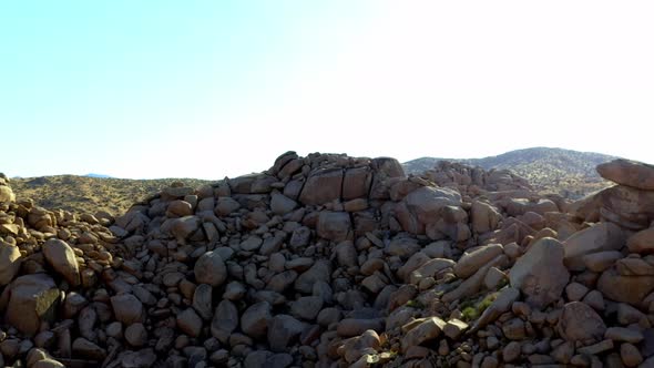 Drone shot flying away from some really big rocks and boulders. alt