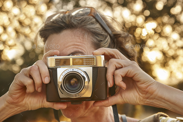 Woman taking pictures with vintage camera. Travel background. Vacation