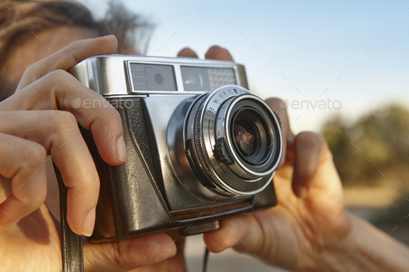 Woman taking pictures with vintage camera. Travel background. Vacation