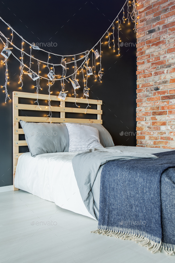Bed with decoration next to brick wall