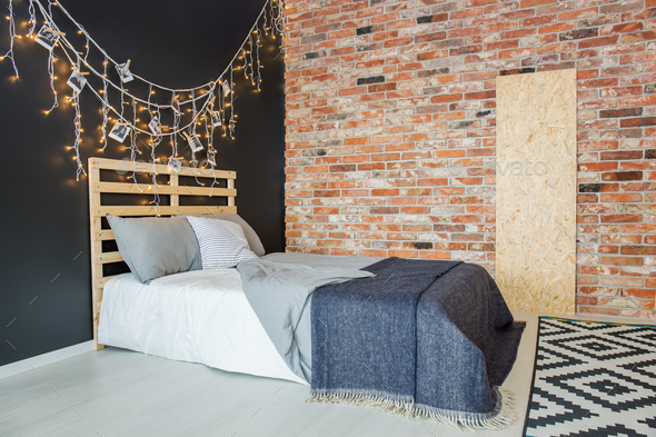 Bed in bedroom with brick wall