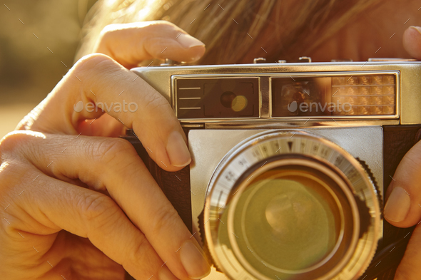 Woman taking pictures with vintage camera. Travel background.