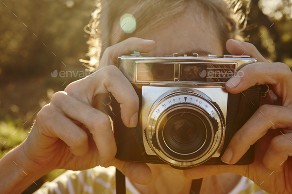 Woman taking pictures with vintage camera. Travel background.