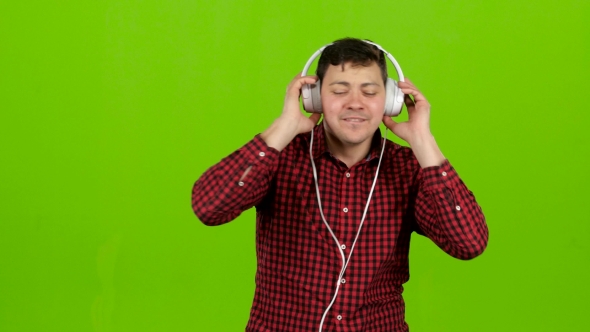 Guy Listens To Energetic Music in Headphones and Dances. Green Screen alt