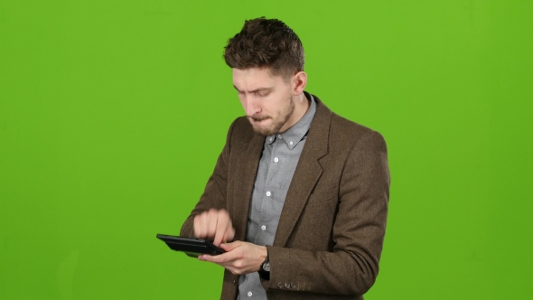 Businessman Considers the Profit on the Calculator and He Is Bankrupt. Green Screen alt