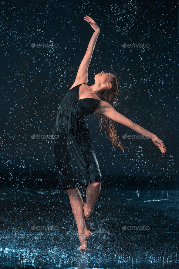 The young beautiful modern dancer dancing under water drops