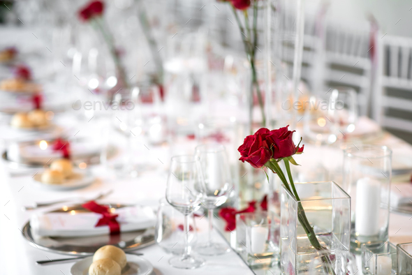 Formal dinner table setting with red roses