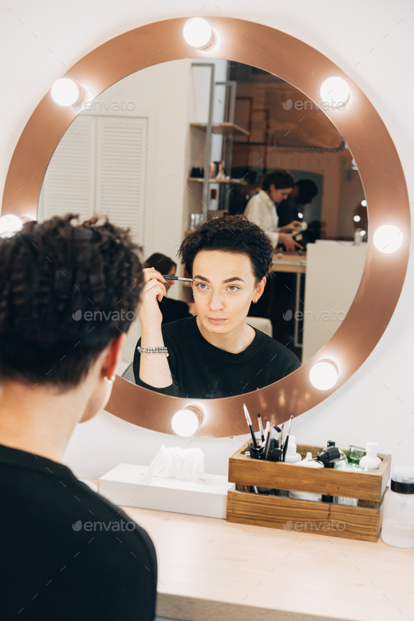 Attractive woman at the mirror in beauty studio - Stock Photo - Images