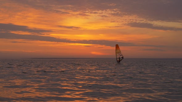 Watersports in Sea. Sailboard at Sunset.