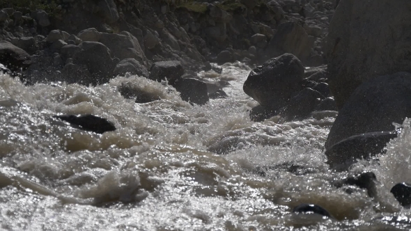 Fast Mountain River Splashing at Huge Stones