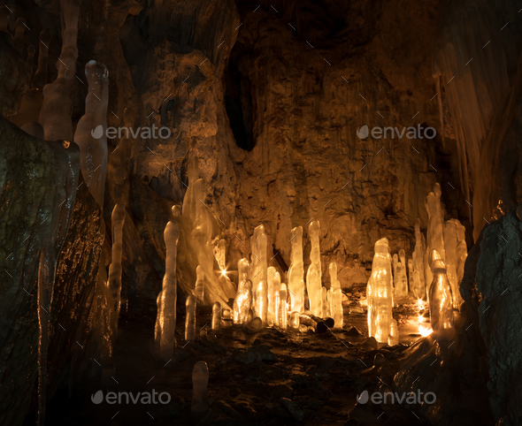 Ice stalagmites in a cave illuminated by candles - Stock Photo - Images