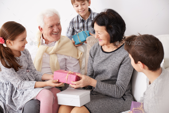 Grandchildren giving presents to grandparents