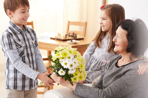 Grandson giving flowers to grandma
