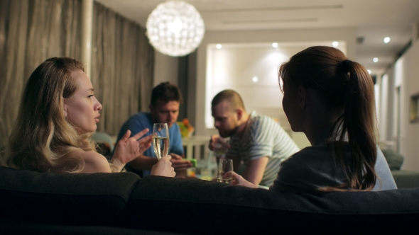 Two Couples Spend an Evening in a Cozy Livng Room, They Communicate and Drink Champagne alt