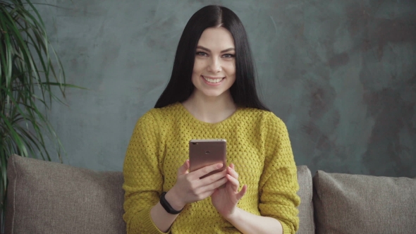 Happy Young Woman Using Smartphone at Home